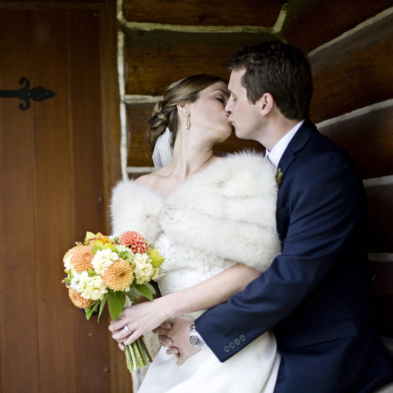 engagement photography of the bridge and groom to be bundled up in a blanket outside in a field