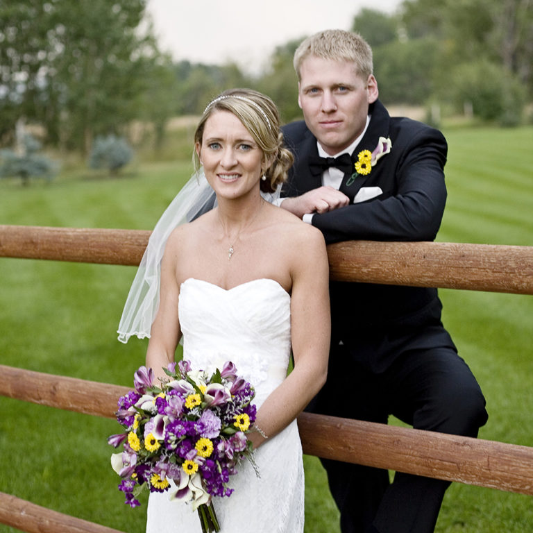wedding photography of a bride holding her bouquet and smiling over her shoulder outside