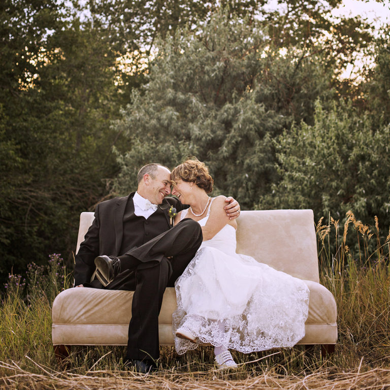 wedding photography of a bride holding her bouquet and smiling over her shoulder outside