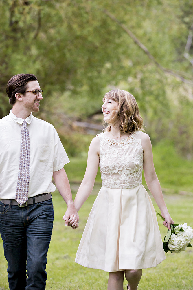 engagement photography of the bridge and groom to be bundled up in a blanket outside in a field