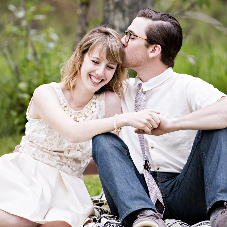 wedding photography of a bride holding her bouquet and smiling over her shoulder outside