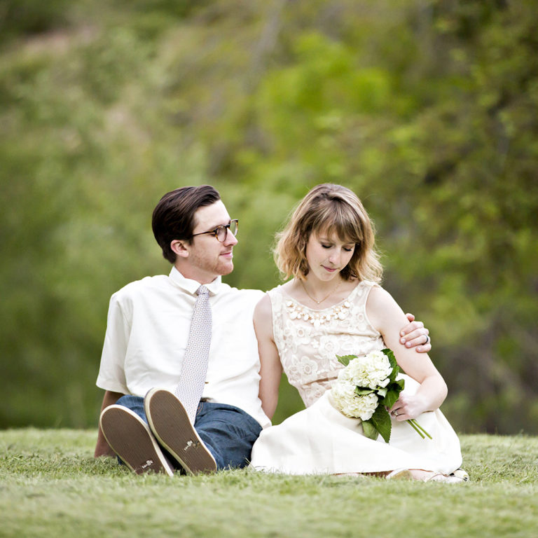 engagement photography of the bridge and groom to be bundled up in a blanket outside in a field