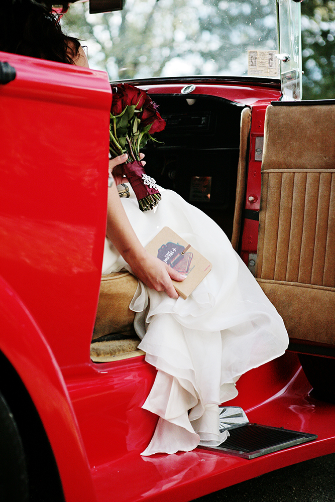 wedding photography of a bride holding her bouquet and smiling over her shoulder outside