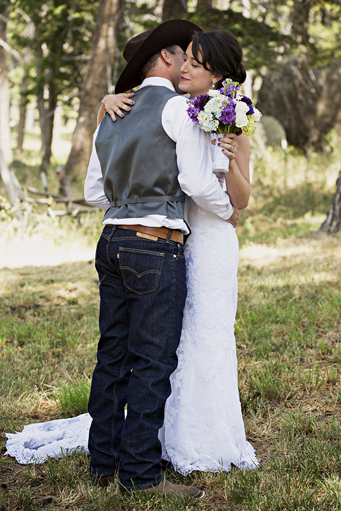 engagement photography of the bridge and groom to be bundled up in a blanket outside in a field