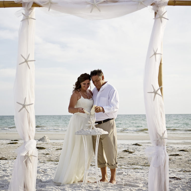 engagement photography of the bridge and groom to be bundled up in a blanket outside in a field