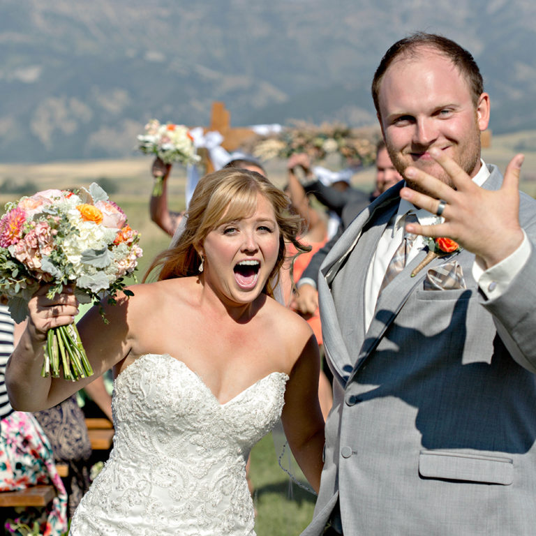 wedding photography of a bride holding her bouquet and smiling over her shoulder outside