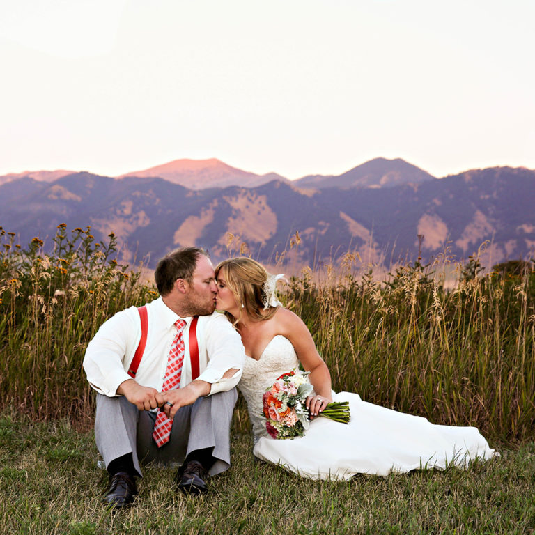 wedding photography of a bride holding her bouquet and smiling over her shoulder outside