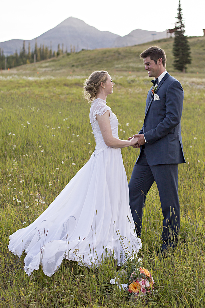 wedding photography of a bride holding her bouquet and smiling over her shoulder outside