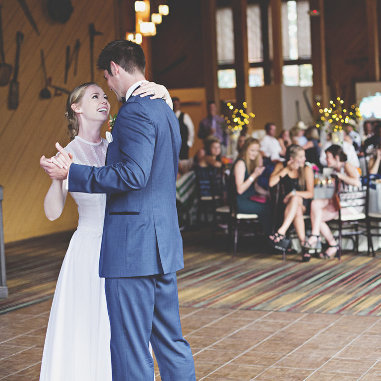 wedding photography of a bride holding her bouquet and smiling over her shoulder outside