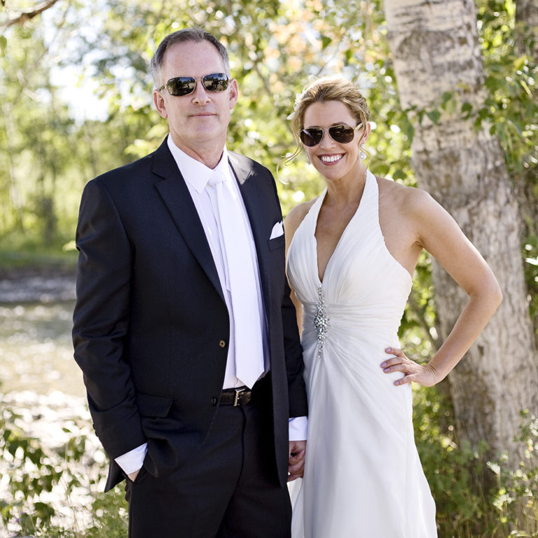 engagement photography of the bridge and groom to be bundled up in a blanket outside in a field