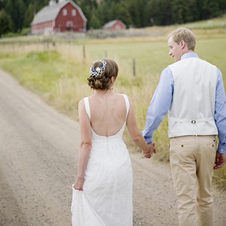 wedding photography of a bride holding her bouquet and smiling over her shoulder outside