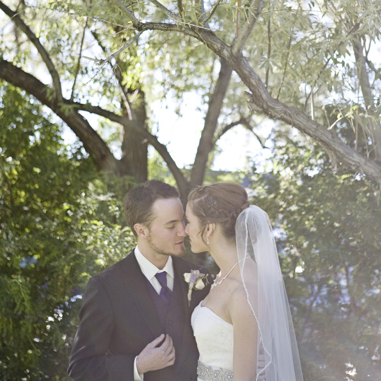 engagement photography of the bridge and groom to be bundled up in a blanket outside in a field