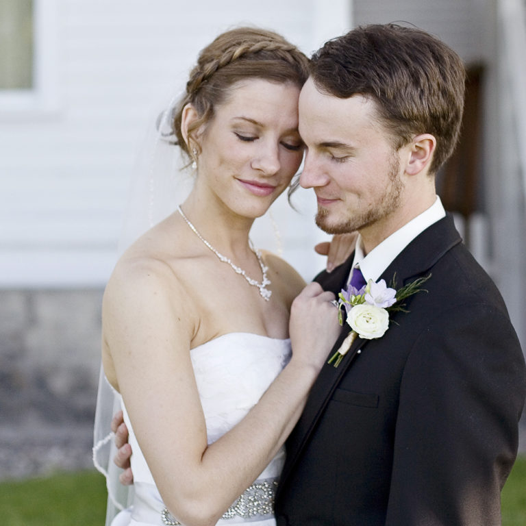 wedding photography of a bride holding her bouquet and smiling over her shoulder outside