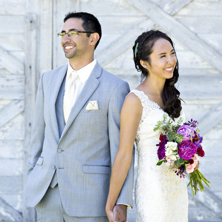 engagement photography of the bridge and groom to be bundled up in a blanket outside in a field