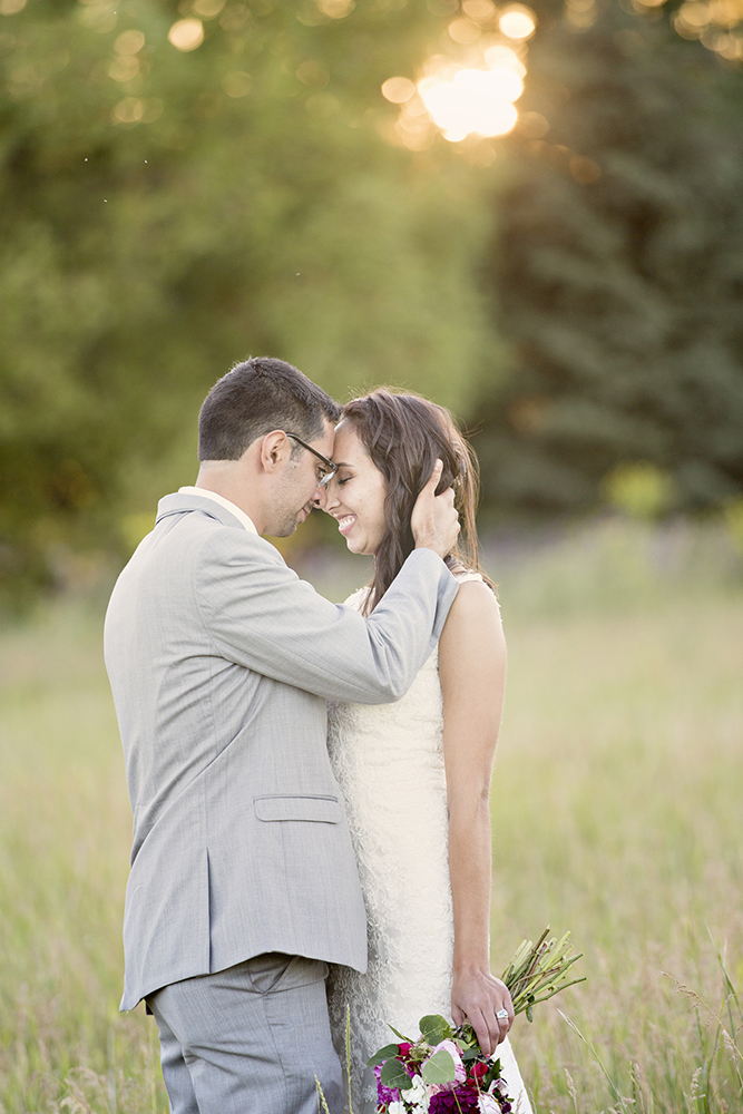 wedding photography of a bride holding her bouquet and smiling over her shoulder outside