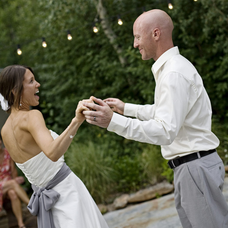 engagement photography of the bridge and groom to be bundled up in a blanket outside in a field