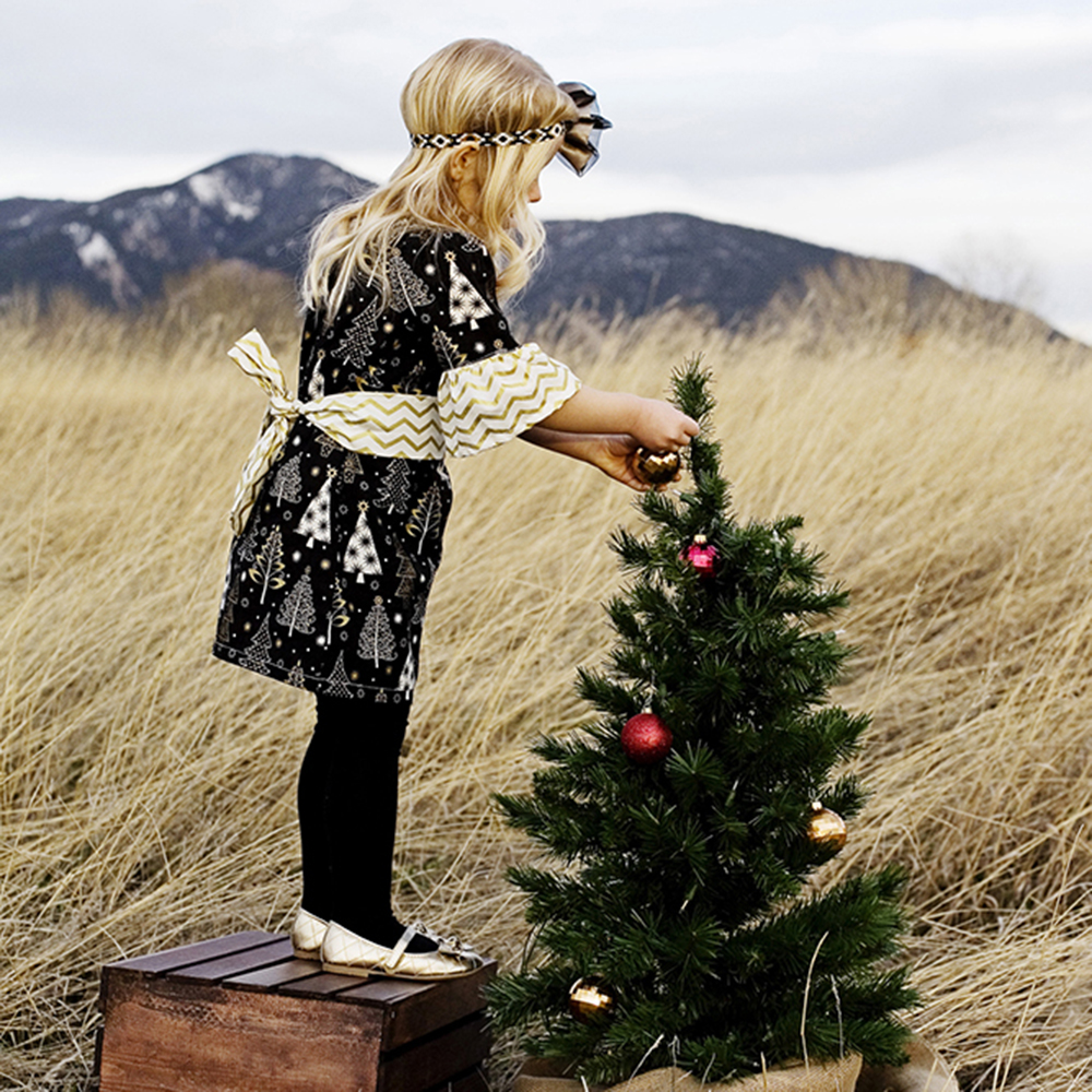 holiday portrait photography of two young sisters dressed for the holidays outside surrounded by decorations
