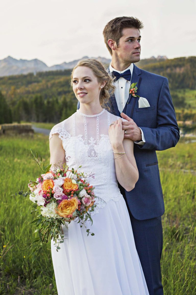 wedding photography of bride and groom holding each other and kissing outside at dusk