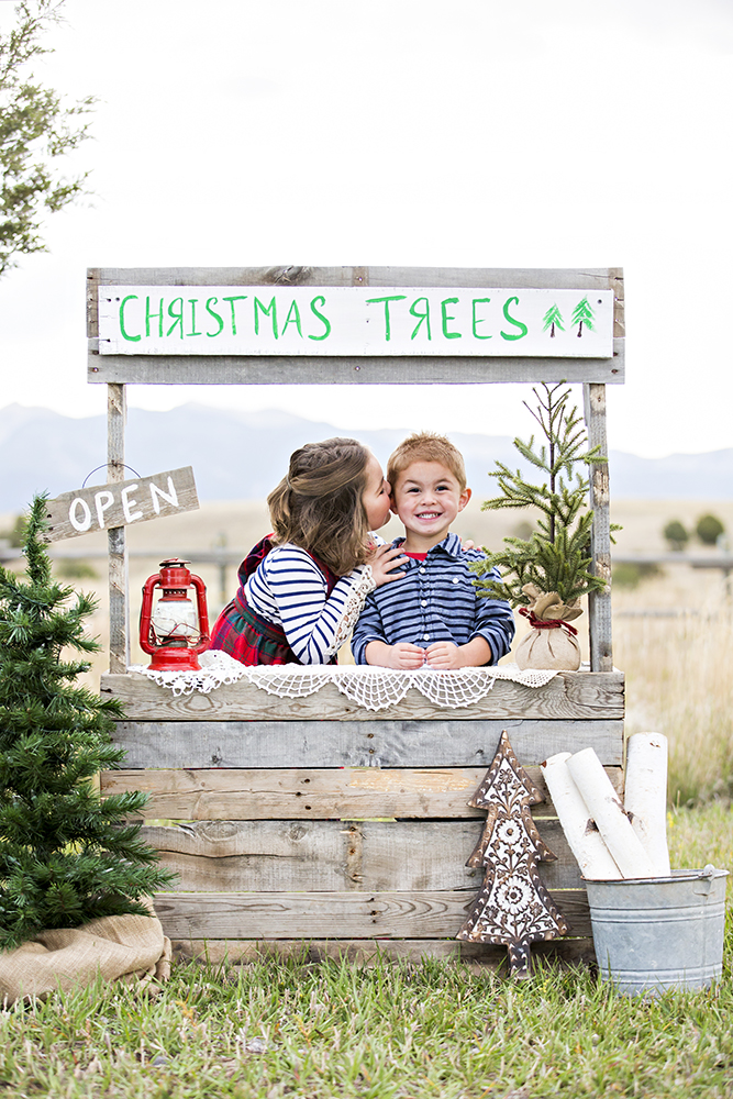 holiday portrait photography of two sisters sitting outside on a blanket laughing dressed for the holidays