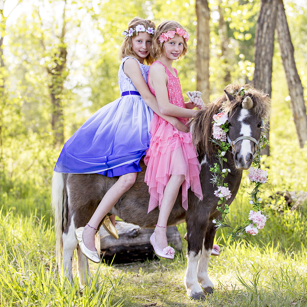 holiday portrait photography of two young sisters dressed for the holidays outside surrounded by decorations