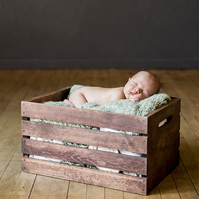 newborn photography of a newborn baby girl sleeping swaddled in a teal blanket