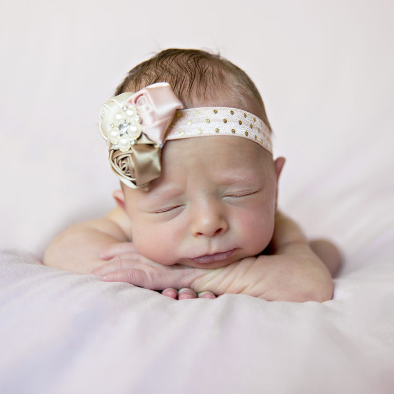 newborn photography of a new father smiling down at his newborn baby yawning in his arms