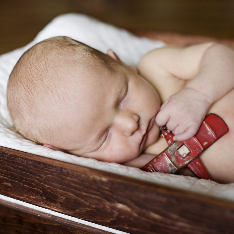 newborn photography of a newborn baby girl sleeping swaddled in a teal blanket