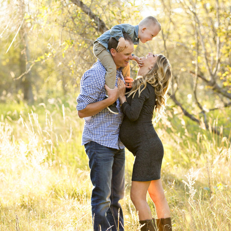 newborn photography of a new father smiling down at his newborn baby yawning in his arms