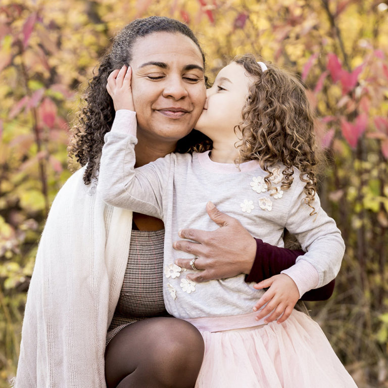 family portrait photography of a young boy smiling wide with his eyes closed outside