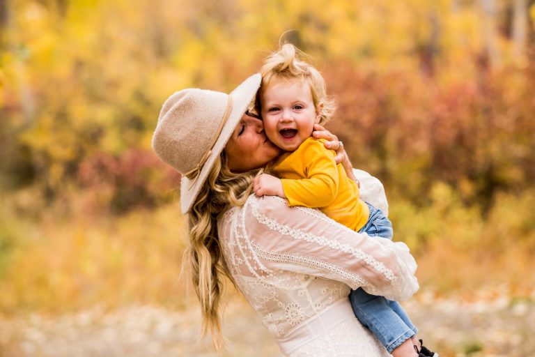 family portrait photography of a young girl holding toy arrows in front of a cabin