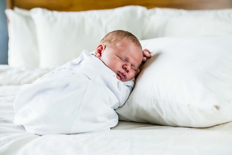 newborn photography of a new father smiling down at his newborn baby yawning in his arms