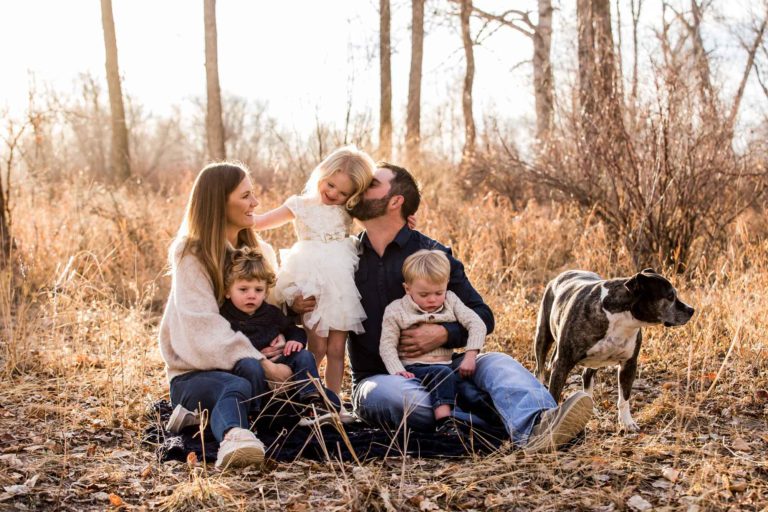 family portrait photography of a young boy smiling wide with his eyes closed outside