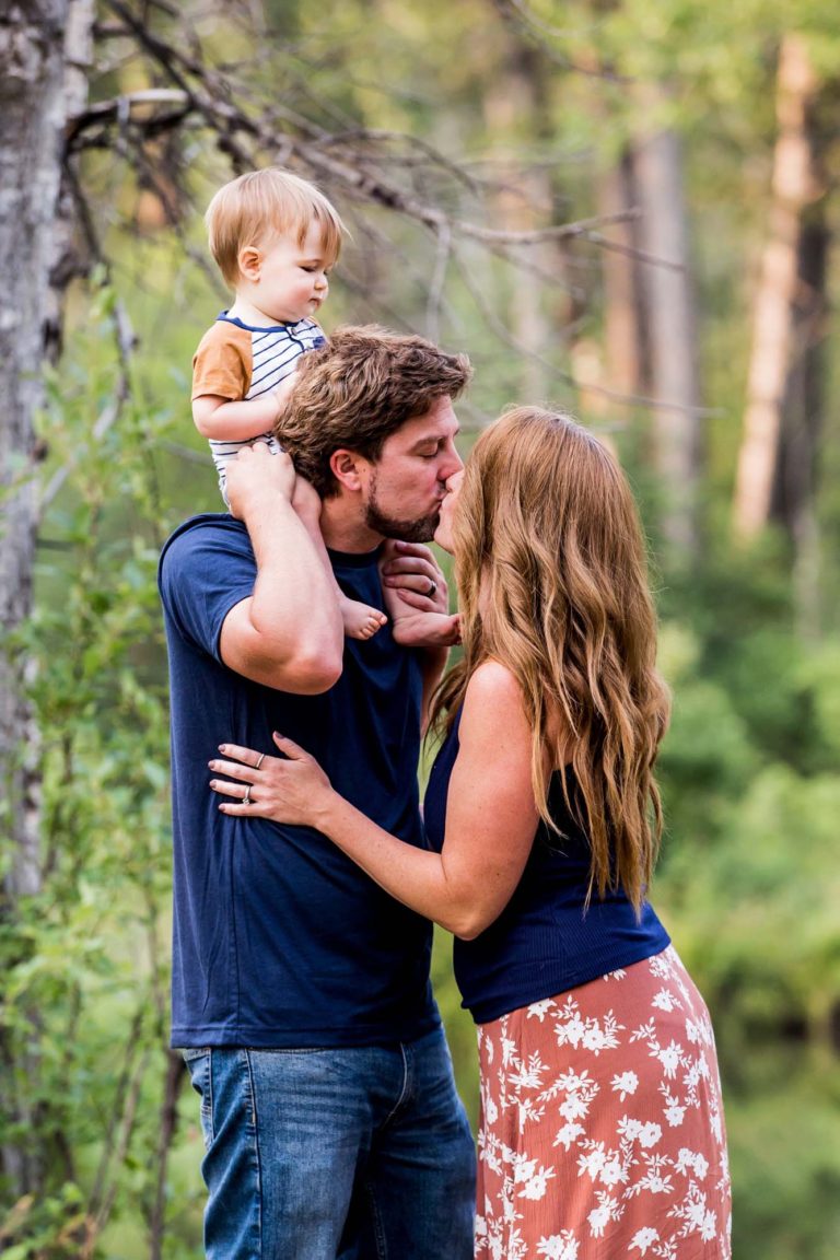 family portrait photography of a young boy smiling wide with his eyes closed outside