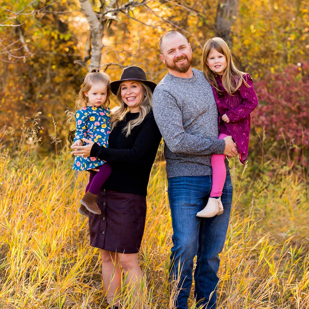 Parents standing together with their children in nature captured by a family photographer in Bozeman MT
