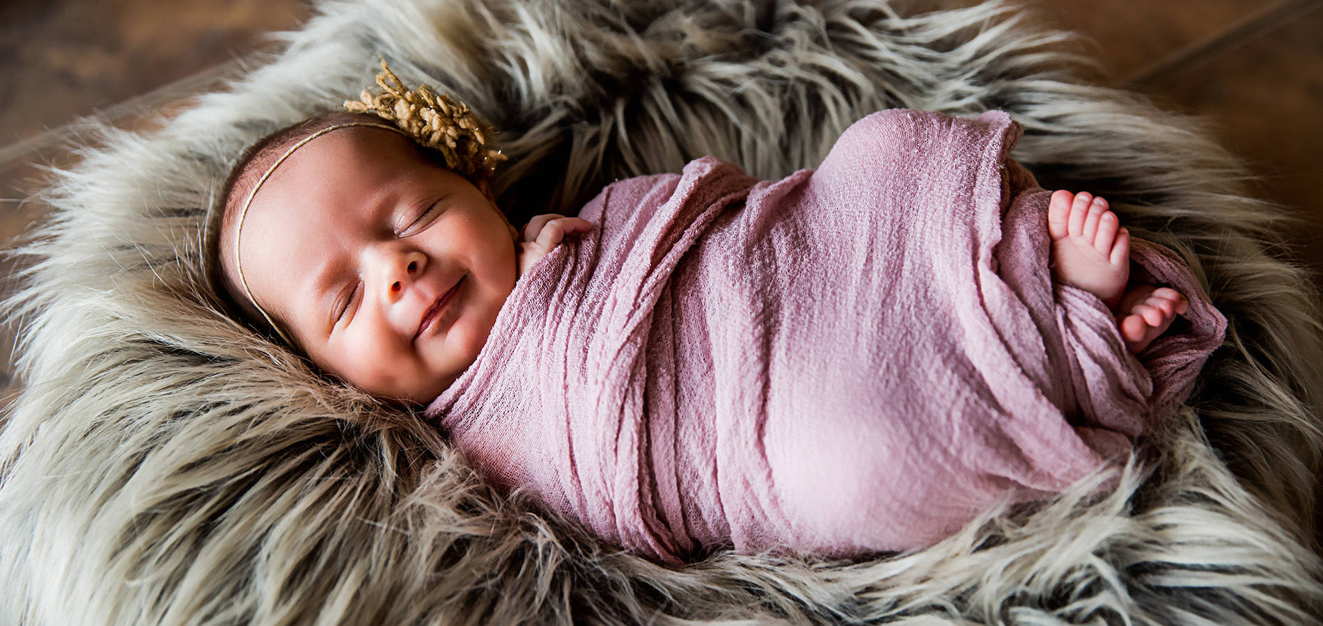 close up newborn photography of a swaddled baby in white