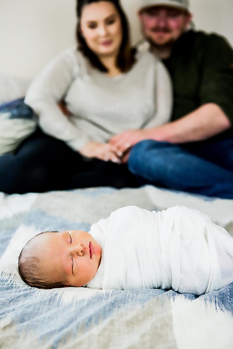 newborn photography of a newborn baby girl sleeping swaddled in a teal blanket