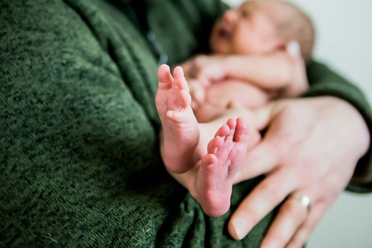 newborn photography of a newborn baby girl sleeping swaddled in a teal blanket