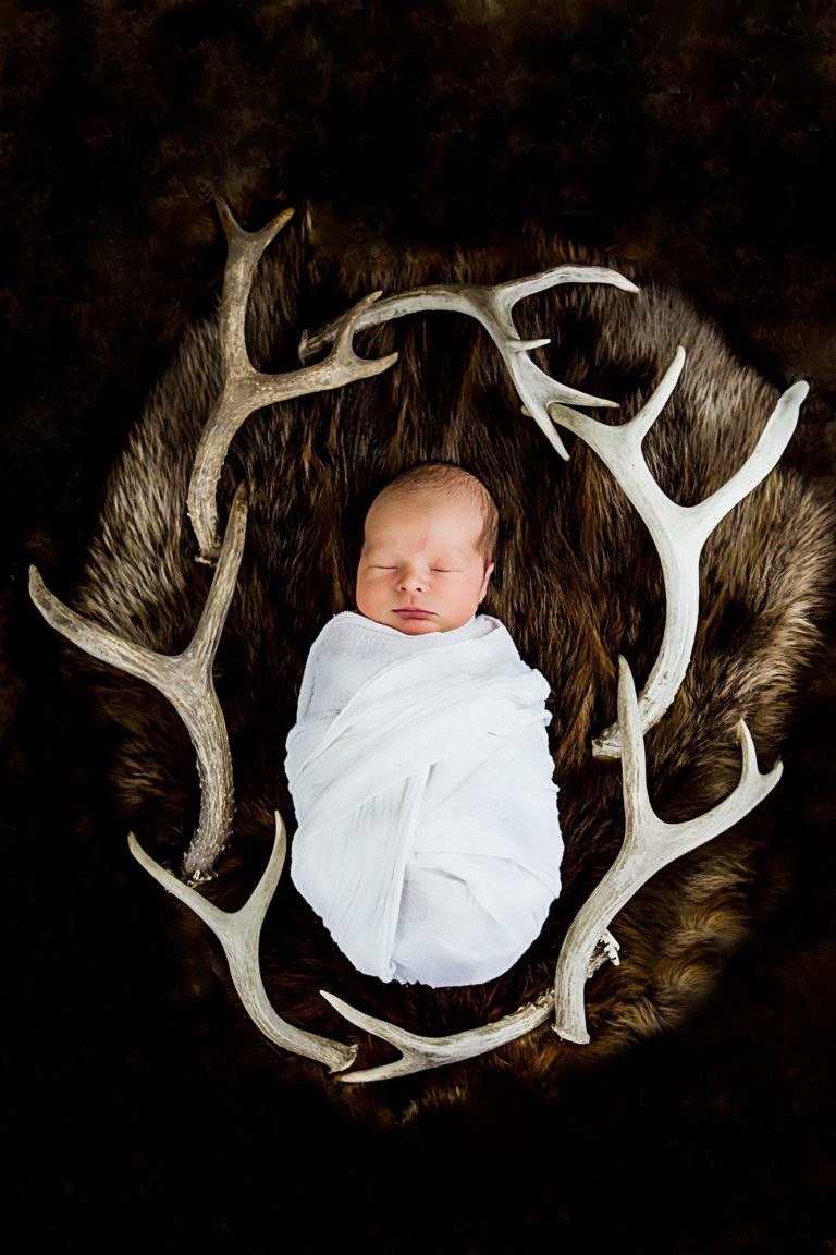 newborn photography of a newborn baby girl sleeping swaddled in a teal blanket