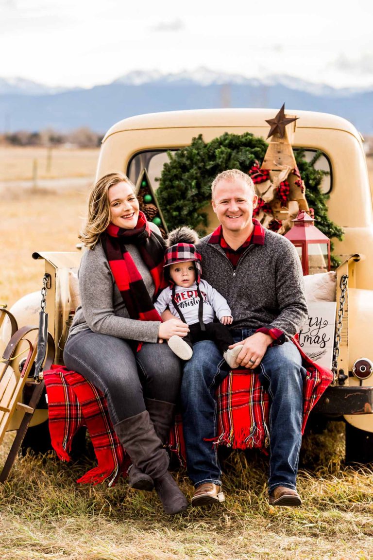 family portrait photography of a husband and wife smiling in a field