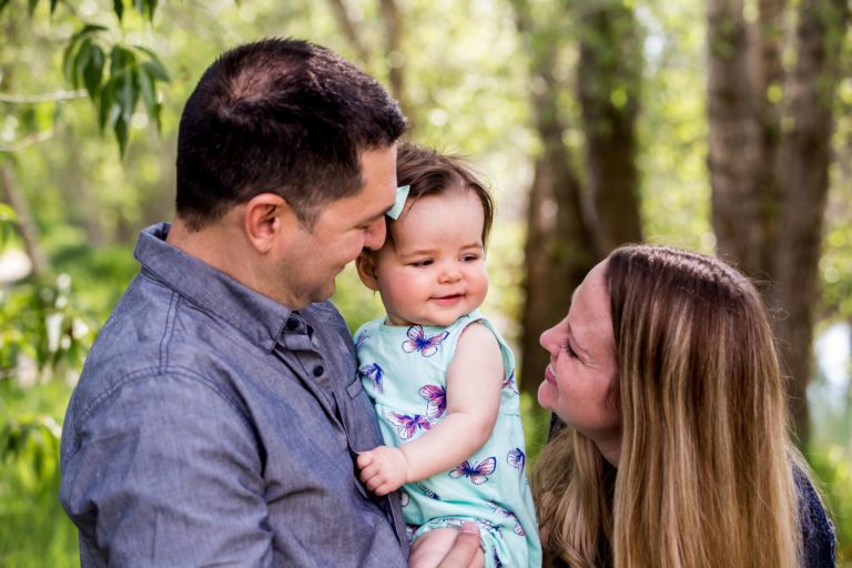 family of three standing close at the Gallatin River Hideaway