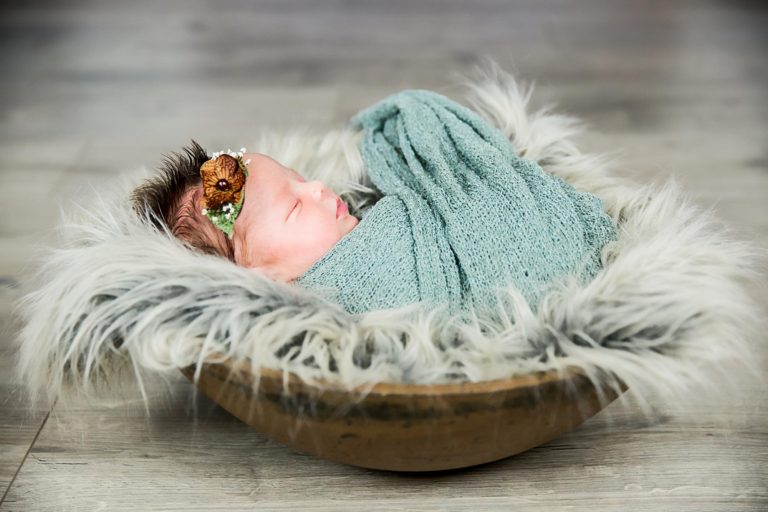 newborn photography of a new father smiling down at his newborn baby yawning in his arms