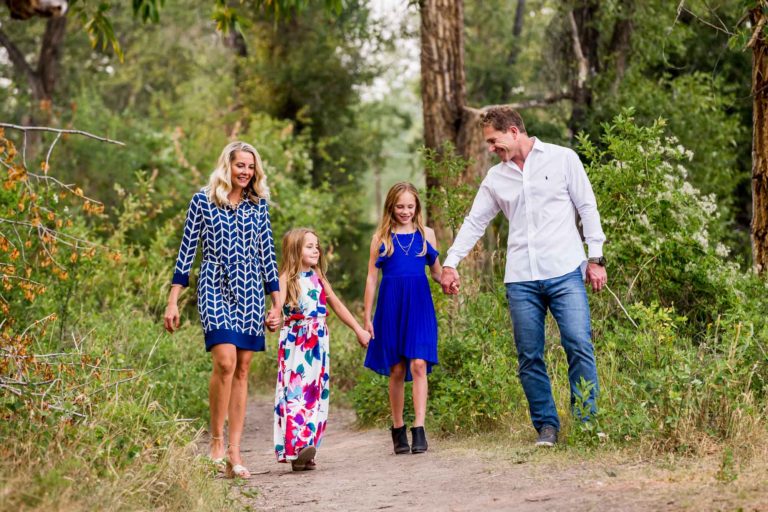 Father, mother and two daughters walking along wooded path at the Irwin Bridge fishing access