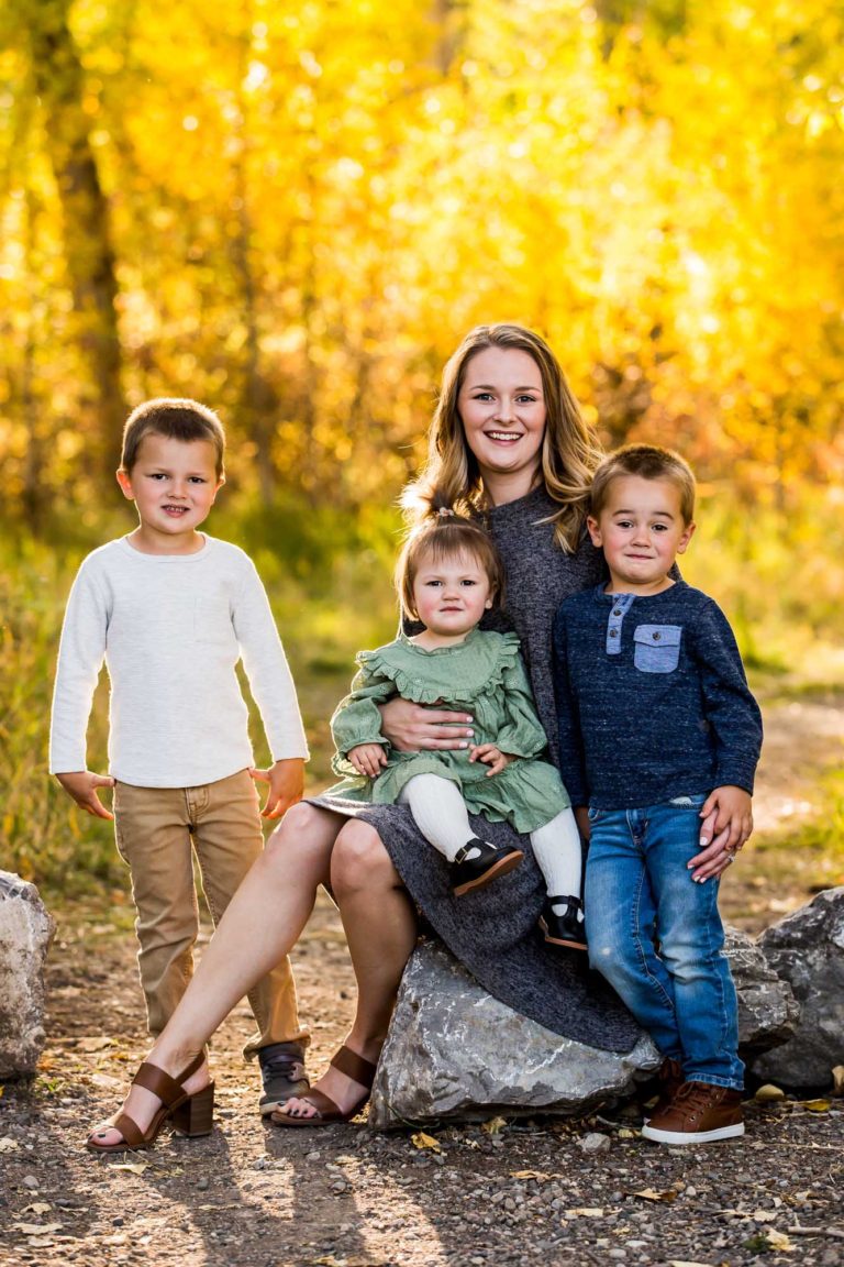 family portrait photography of a husband and wife smiling in a field