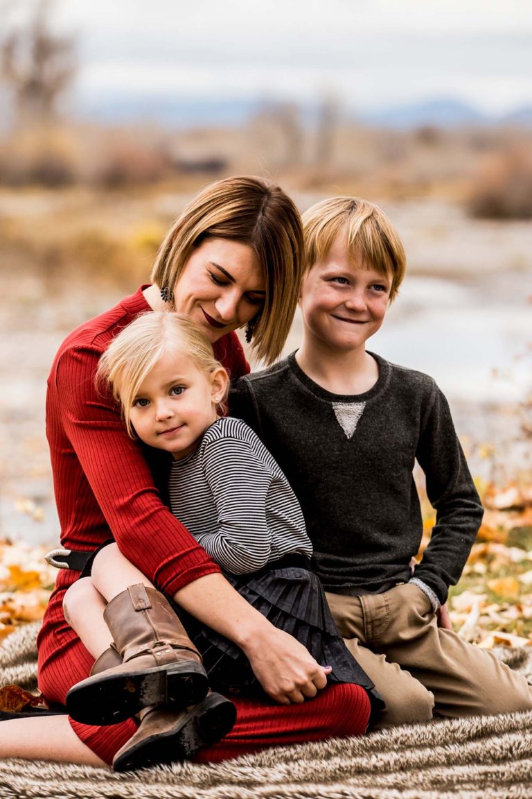 family portrait photography of a mother, father, and teenage daughter walking hand in hand through a field