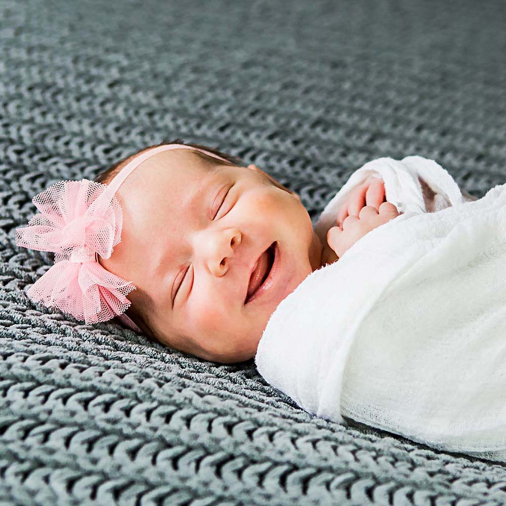  newborn photography of a newborn baby curled up sleeping on a white blanket